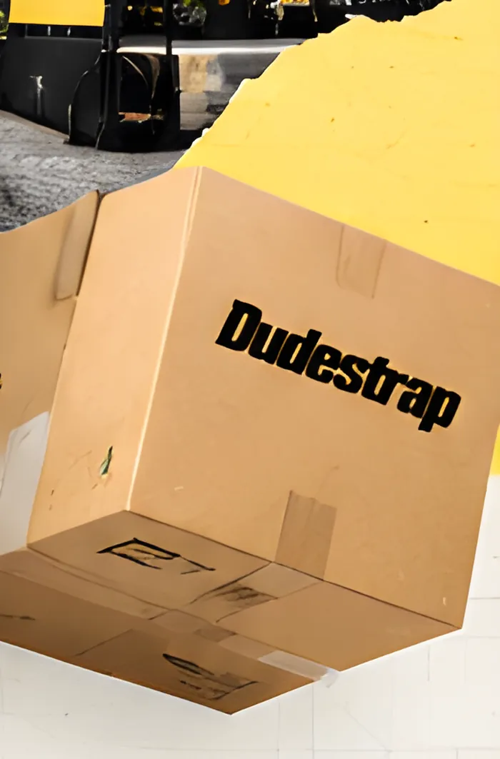 A cardboard shipping box printed with the Dudestrap logo